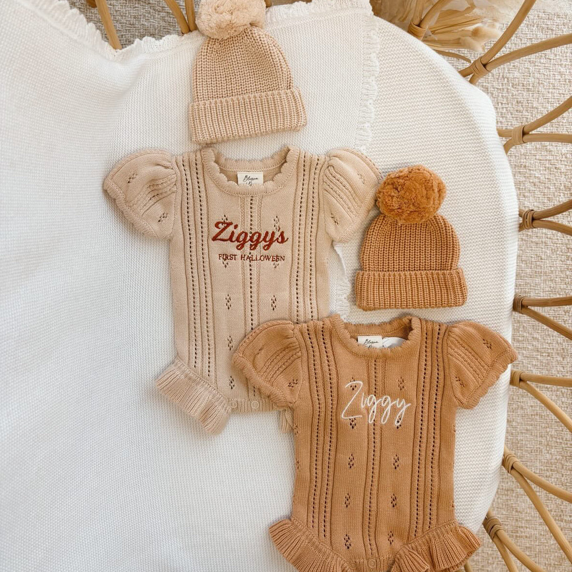 Two personalised pointelle knit baby rompers embroidered with a name and First Halloween, with matching pom beanies