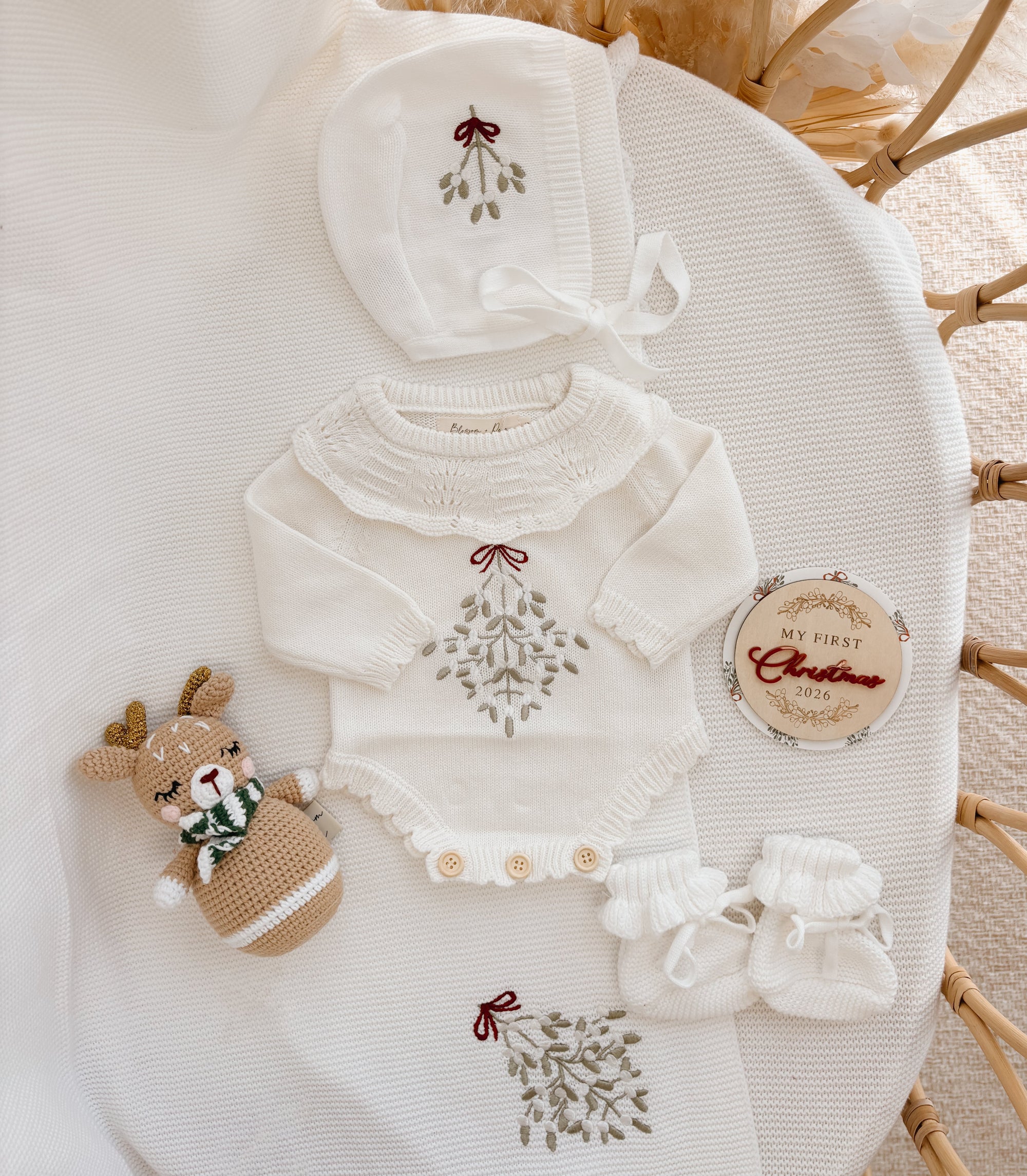 Mistletoe embroidered knit baby romper with a pointelle yoke, bonnet, booties and crochet reindeer rattle