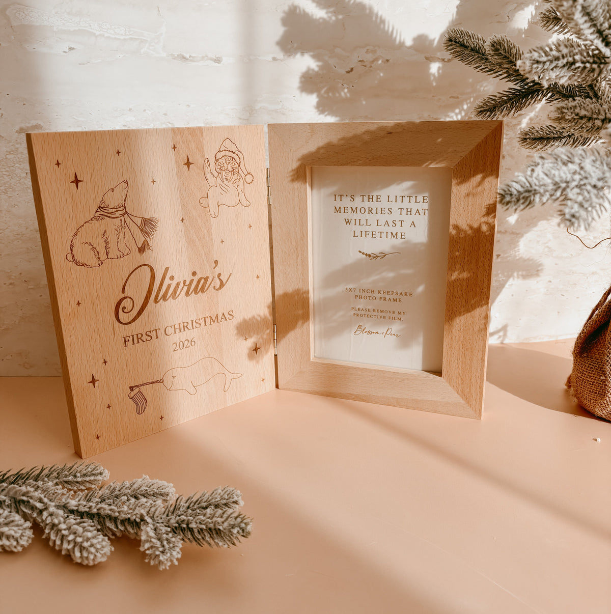 Personalised wooden keepsake photo frame standing upright, engraved 'Olivia's First Christmas 2026' with polar bear, santa and seal line art