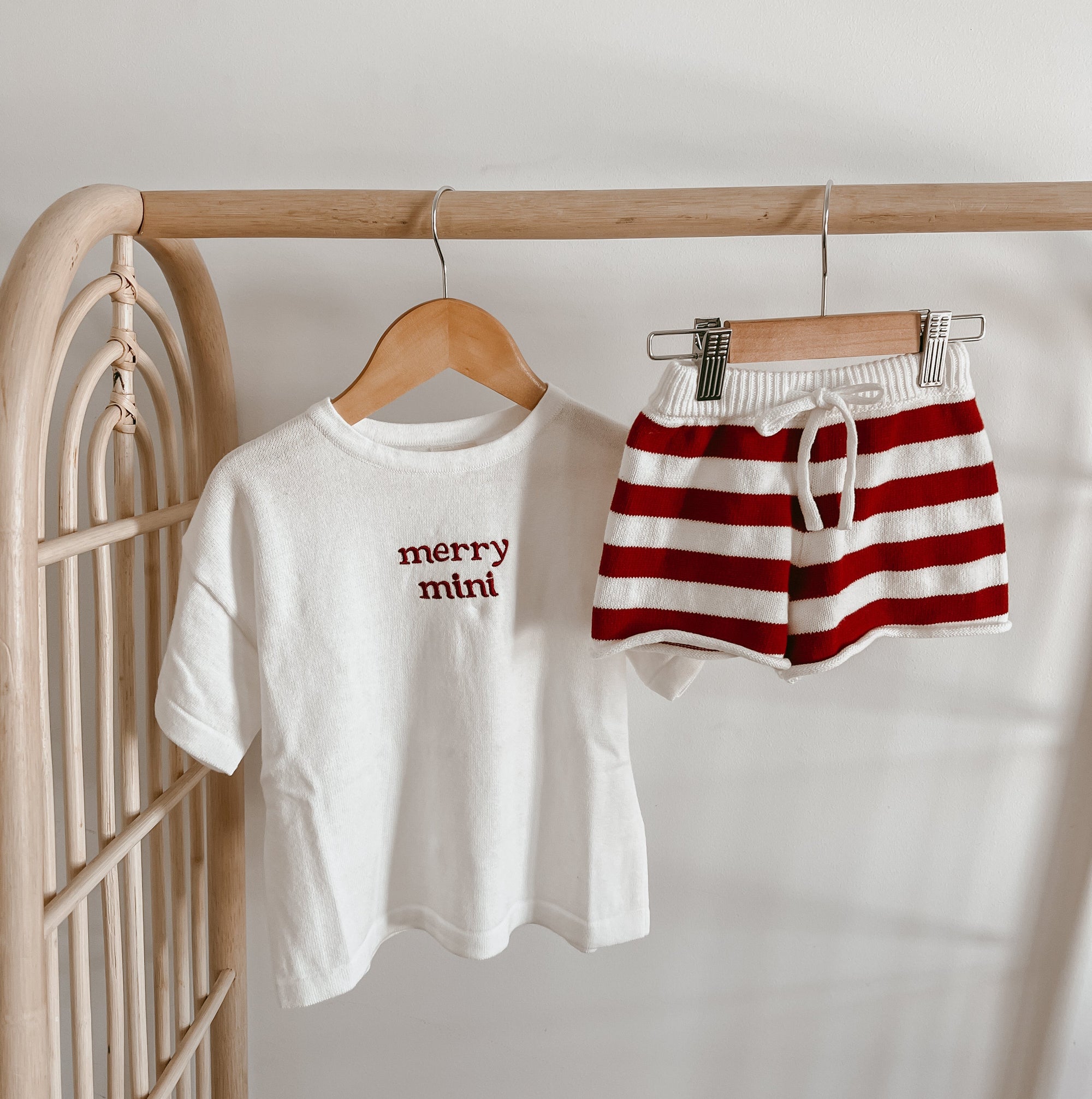 Merry mini embroidered tee hung beside matching red and white stripe knit shorts