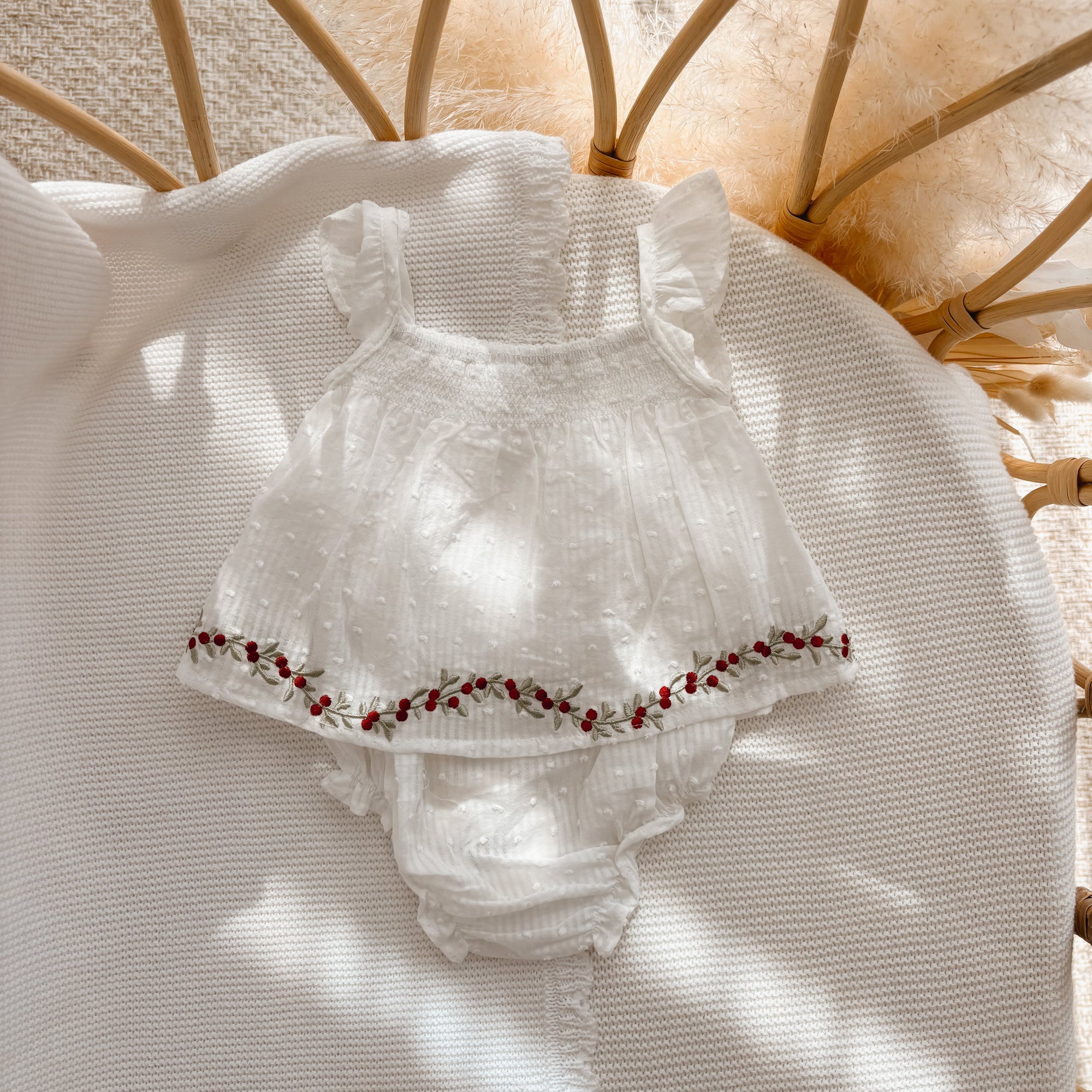 White frill sleeve baby top and bloomer set with red holly berry embroidery along the hem