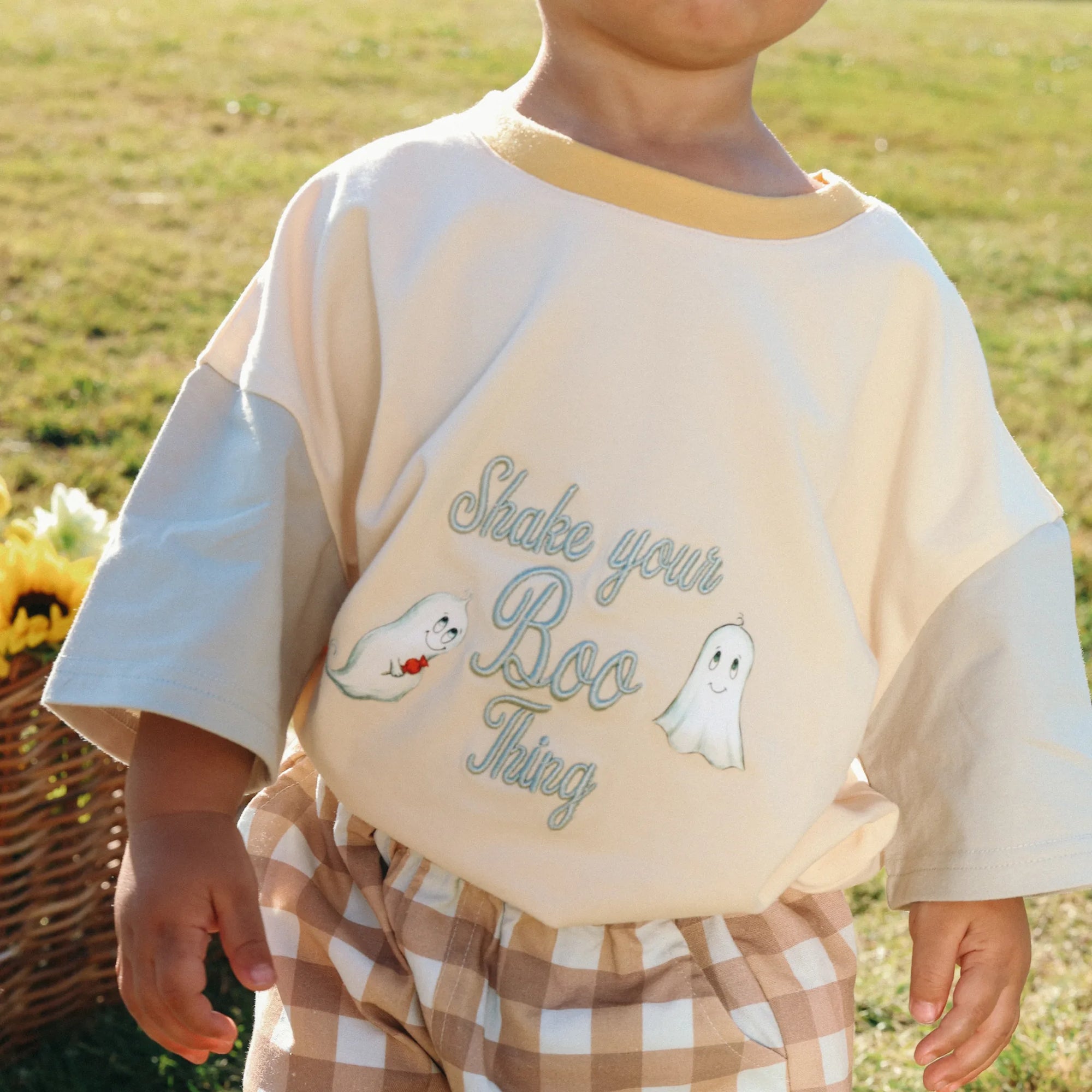 Close up of a Shake Your Boo Thing ghost print tee worn with tan gingham shorts