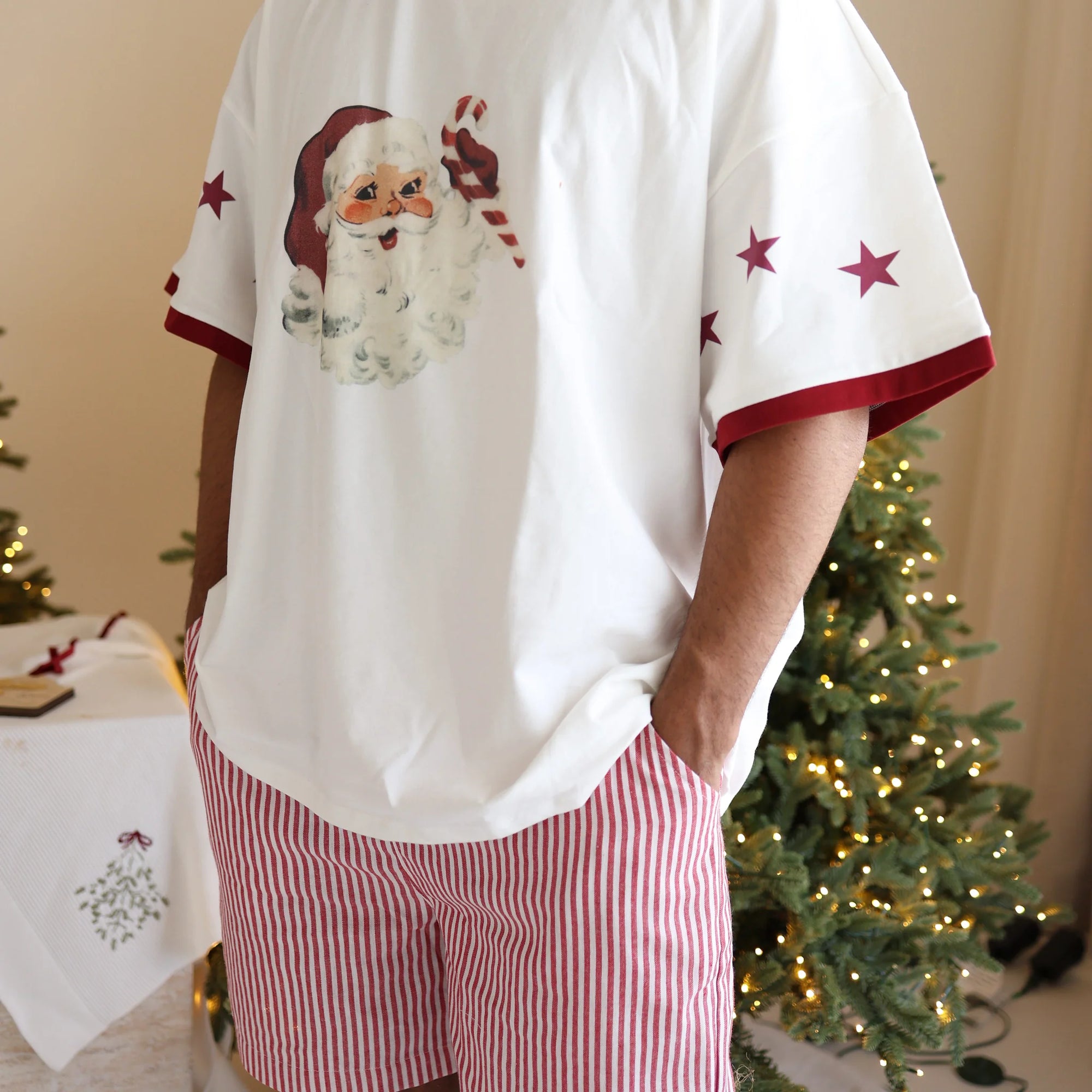 Back view of a men's vintage Santa print tee with star sleeve detail, worn with red stripe pyjama shorts